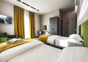 斯库台Nord Hotel Boutique的酒店客房,设有3张带黄色窗帘的床