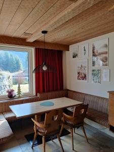 比伯维尔Alpinum Hostel的一间带桌椅和窗户的用餐室