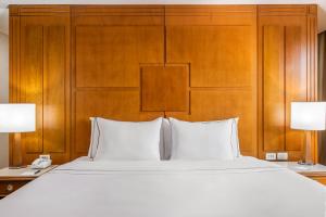 巴西利亚巴西21美利亚酒店的卧室配有一张白色大床和木制床头板