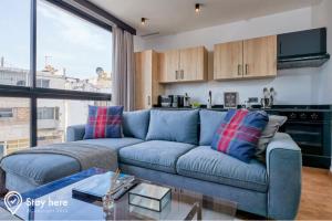 卡萨布兰卡Stayhere Casablanca - Gauthier 1 - Modern Residence的一间带蓝色沙发的客厅和一间厨房