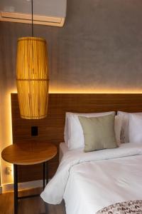 彼得罗波利斯Kastel Petrópolis的一间卧室配有一张床、一张桌子和一盏灯