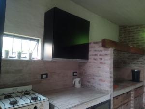 科连特斯ESPACIO MINGA, casa quinta en la ciudad, hasta 8 personas的一间带炉灶的厨房和一台墙上的电视