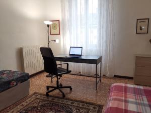克雷莫纳AT HOME IN CREMONA的客房设有一张桌子和一台笔记本电脑