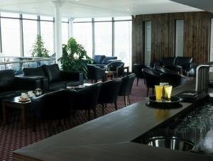 阿什本阿什伯恩酒店的一间设有黑色椅子的餐厅和一间酒吧