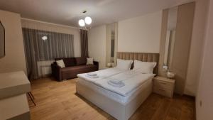 班斯科Guest House Gogemi的卧室配有一张白色的大床和一张沙发。