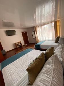 波哥大Hotel Maceo Chico的酒店客房带两张床和一个游泳池