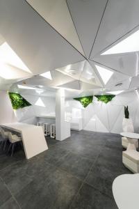 马德里Optimi Rooms Madrid的办公室拥有白色的墙壁和带灯的天花板