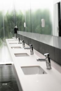 马德里Optimi Rooms Madrid的浴室里一排带镜子的盥洗盆