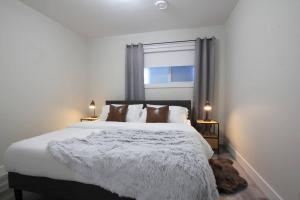 埃德蒙顿Executive Bsmt Suite, King Bed, 5 min to DT & Whyte Ave, Sleeps 6!的卧室配有一张大白色床和窗户