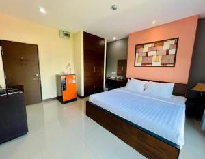 南邦马别致及舒适公寓式酒店的一间卧室配有一张带橙色墙壁的大床