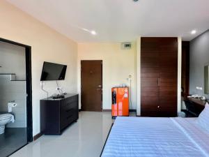 南邦马别致及舒适公寓式酒店的酒店客房设有床、电视和浴室。