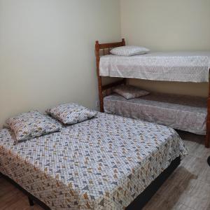 佩洛塔斯Pousada Casa Valério的一间卧室设有两张单人床和楼梯。