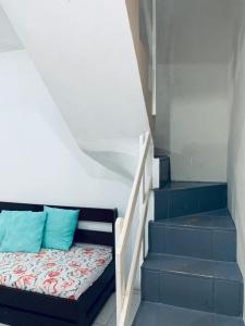 卡庞达卡诺阿Pousada Portal da Praia的一张位于楼梯旁的带蓝色枕头的床