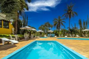 Simão PereiraHotel Fazenda Minas Real的度假村的游泳池,配有椅子和遮阳伞