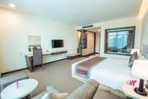 Diễn Châu芒人坦迪恩拉姆豪华酒店的酒店客房设有一张大床和一张沙发。