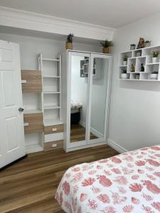 奥克利Oakleigh Private unit的一间卧室配有一张床和一个带镜子的衣柜