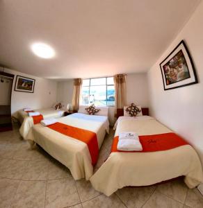 阿亚库乔Sumaq Dreams Ayacucho的酒店客房设有三张床和窗户。
