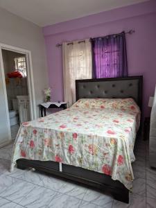 苏弗里耶尔Coco Rose Apartments的一间卧室配有一张带花卉床罩的床