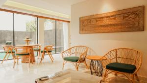 塞米亚克Annora Villas Seminyak的用餐室配有木椅、桌子和桌椅