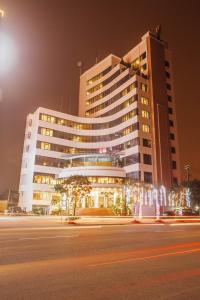 荣市孟坦比涅酒店的一座大建筑,在晚上,前面有一条街道