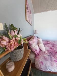 CorryongJardine Lodge - Can sleep 22!的一间卧室配有一张床和一张鲜花桌子