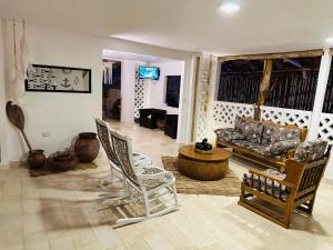 阿沃莱特斯El Faro Hostel的客厅配有椅子和沙发