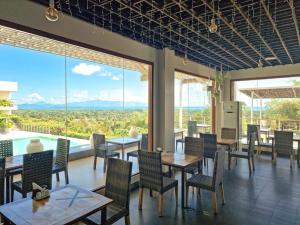 公主港巴拉望岛番加度假酒店的餐厅设有桌椅和大窗户。