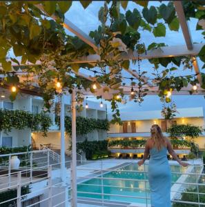 公主港巴拉望岛番加度假酒店的站在带游泳池的建筑物阳台的女人