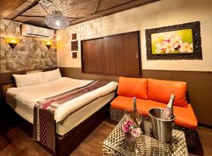 川崎Hotel Gran Bali Resort的一间卧室配有一张床、一张沙发和一把椅子