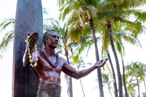 檀香山Wayfinder Waikiki的站在柱子旁边的男人的雕像