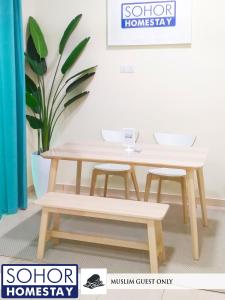 樟仑Sohor Homestay Changlun的一张木桌和两张凳子
