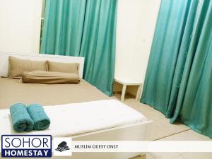 樟仑Sohor Homestay Changlun的一间卧室配有蓝色窗帘的床