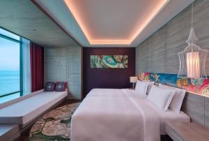 峇都丁宜Angsana Teluk Bahang的卧室配有一张白色的大床和一张沙发。