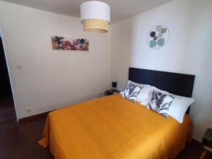 圣吉尔莱班BLUE SUMMER T3 - vue sur mer - Saint Gilles les Bains的一间卧室配有带枕头的大型橙色床