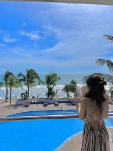 美奈汉罗2号度假酒店的一位从度假游泳池望海的女士