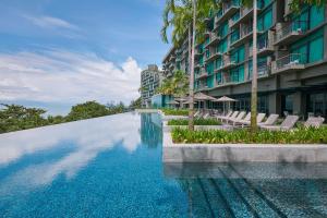 峇都丁宜Angsana Teluk Bahang的大楼前的游泳池