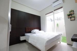 Villa Brassia - 3 Bedrooms的卧室配有一张白色大床和木制床头板