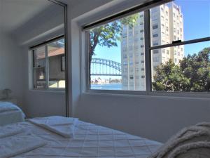 悉尼Spectacular Views of Sydney Harbour with Free Parking的一间卧室设有一张床和一个享有桥梁美景的窗户。