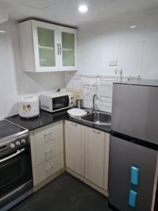 Bang KapiOmni Tower 2 Bed Room Sukhumbit Best Apartment的一间带冰箱和水槽的小厨房