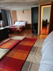 Bang KapiOmni Tower 2 Bed Room Sukhumbit Best Apartment的酒店客房带两张床,还有色彩缤纷的地毯。