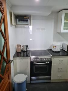 Bang KapiOmni Tower 2 Bed Room Sukhumbit Best Apartment的小厨房配有炉灶和垃圾桶