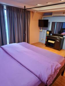 Bang KapiOmni Tower 2 Bed Room Sukhumbit Best Apartment的一间卧室配有一张大床和一架钢琴