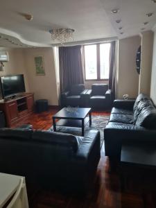 Bang KapiOmni Tower 2 Bed Room Sukhumbit Best Apartment的客厅配有黑色沙发和桌子