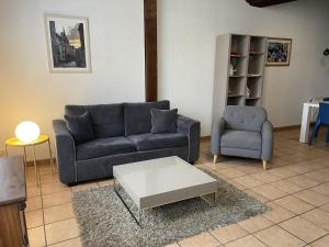 欧塞尔Appartement Le Coche d'Eau Auxerre Les Quais的客厅配有沙发和椅子