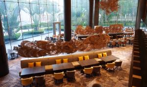 曼谷察殿曼谷大酒店的餐厅设有大窗户和桌椅