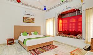 乌代浦Treebo Trend Khakhri Haveli的一间卧室配有床和红色窗帘