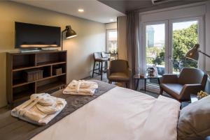 伊斯坦布尔Taxim Suites Residences Istanbul的酒店客房,配有带毛巾的床