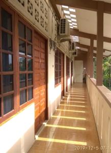 SintangWismaALAS Syariah Guesthouse的一座带木门的建筑的空走廊