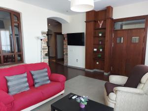 阿洛拉Apartamentos Candela Alora的客厅配有红色的沙发和两把椅子
