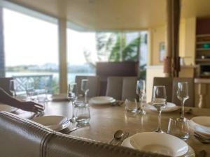悉尼Private Beach Villa on Water's Edge的一张木桌,上面有盘子和玻璃杯